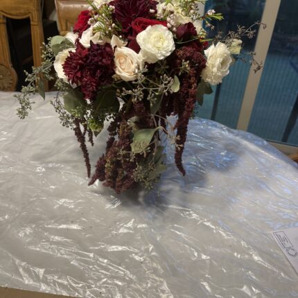 A table with a white and red bouquet of flowers on it