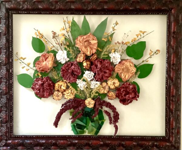A framed picture of flowers in a vase.