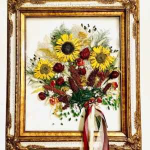 A painting of flowers in a gold frame.